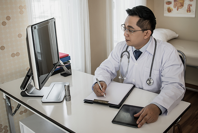Health professional using a computer to refer a client to MensLine Australia